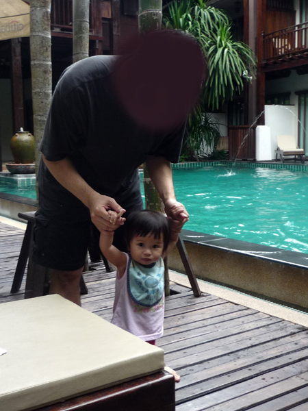 Baby walking on pool deck